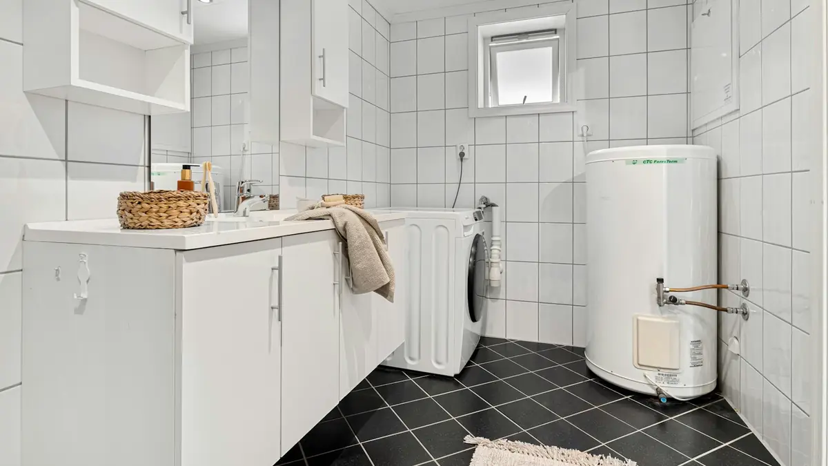 A laundry room with an electric tank water heater beside the washer - Water Heater Repair in Whittier