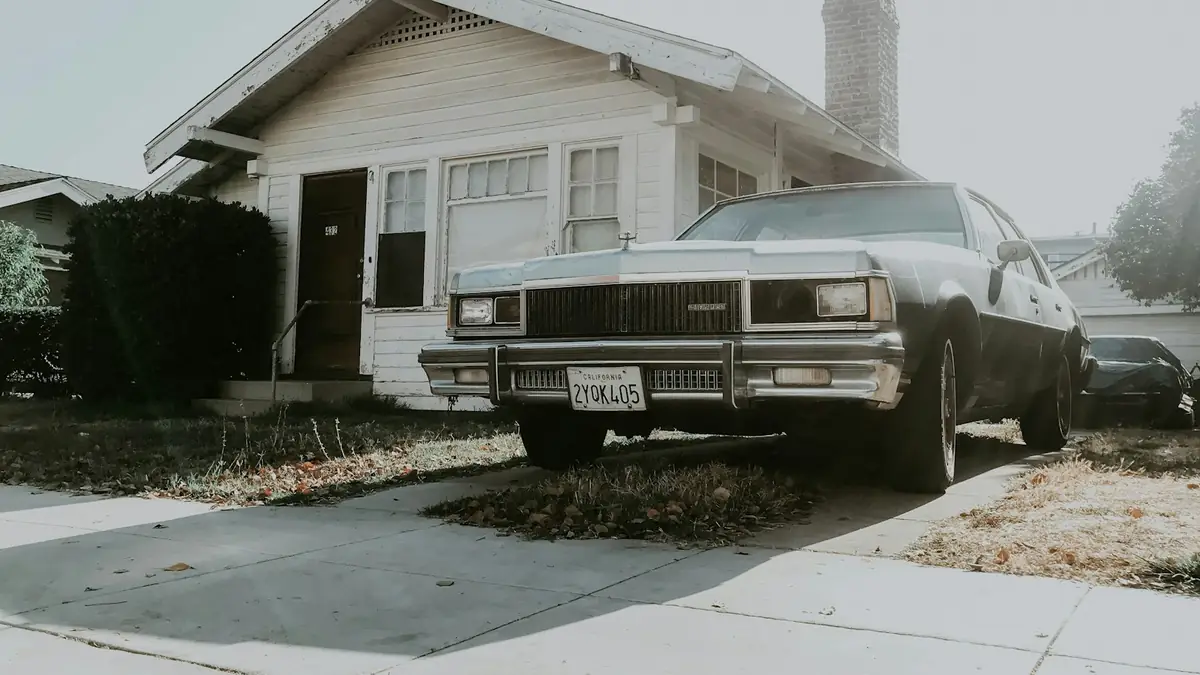 Bungalow with a wide porch and a vintage car out front - Water Heater Replacement in Whittier